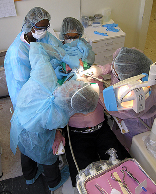 Timothy Garvey, DDS, foreground, performs valuable dental care services at Tacachale's dental clinic. In the background, from left, dental assistants Wanda Price, Carrie Hines and Easie Styles assist the dentist. These team members are essential in delivering effective dental procedures for patients with disabilities