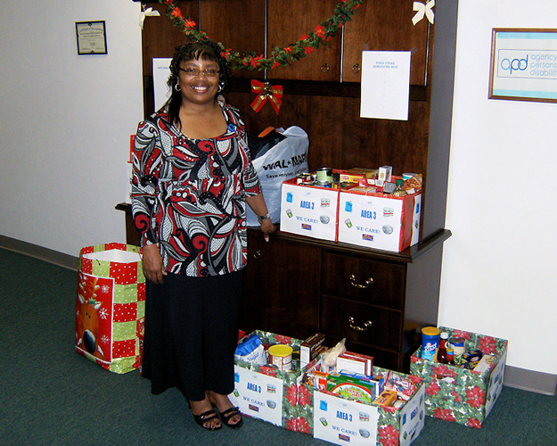 Sandra Cooper poses with Area 3's holiday donations to celebrate the generosity of her fellow employees.