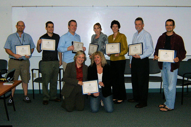 Area 3's Local Review Committee (LRC) Chair Elaine Hutchison and Behavior Specialist Donna Carle, kneeling, from left, present certificates of appreciation to members of the area's LRC. From left, standing are LRC members Greg Jansen, Americo Rodrigues, Jesse Gura, Astrid Hall, Chris LaBelle, Ken McDonald, and Mark Lister. LRC member Tom Moore, who was not available to be in the photo, also was recognized.