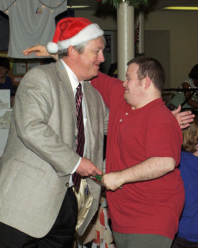 Central Office employee Matt LaFollette, right, gets a gift and a hug from the man in the Santa hat.