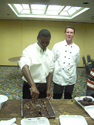 DMD mentee Clayton Rawlings cuts a tray of brownies in the Holiday Inn Cocoa Beach, under the watchful eye of Chef Rich Poirier