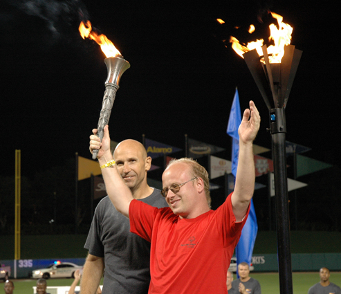 Special Olympics Seminole County athlete Chris Friedman lights the Special Olympics cauldron, joined by Osceola County Sheriff Robert Hansell