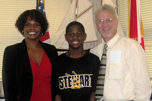 From left, Glorie Singleton takes her son Darius to work on April 23. They are welcomed by Suncoast Area Administrator Carl Littlefield