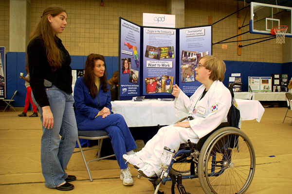 From left, Dana Lachter of VR and APD Communications Director Melanie Mowry Etters chat with Rachel Gerlach, a competitor in SportsAbility's tai kwon do demonstration