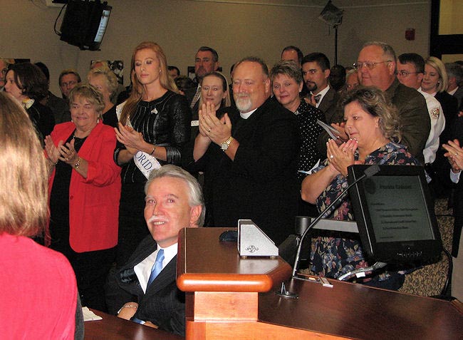 Bay County Property Appraiser Dan Sowell, seated, receives a standing ovation from everyone in attendance at the Cabinet meeting on September 29