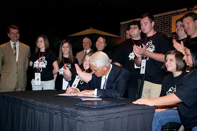 Governor Crist signs Senate Bill 1166 into law, which increases opportunities for people with developmental disabilities to choose where they want to live. Sen. Thad Altman, one of the bill's sponsors, is at left. They are joined by members of the Florida Youth Council