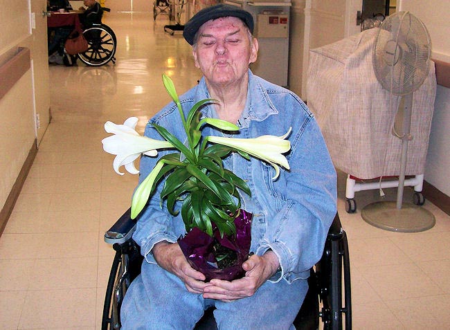 APD customer Charles "Buddy" Kent holds his Easter lily. He loved it so much he didn't want to put it down