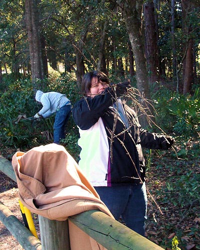 APD-AmeriCorps member Kayla Brouchard tangles with some unruly brambles while member Archie Brown cuts underbrush behind her