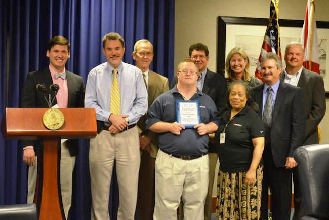 Dignitaries and colleagues from EverBank congratulate APD customer Jason Hamilton as he proudly displays his Employee of the Quarter award. He has worked at the bank for 11 years. 