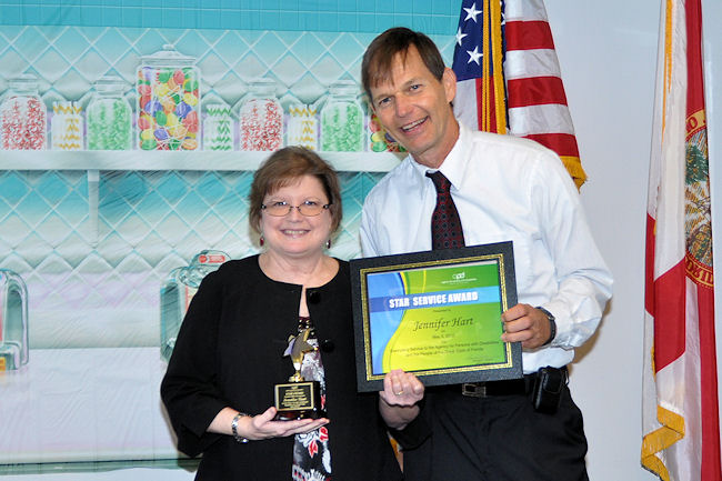 Director Mike Hansen presents a STAR award to Jenny Hart.