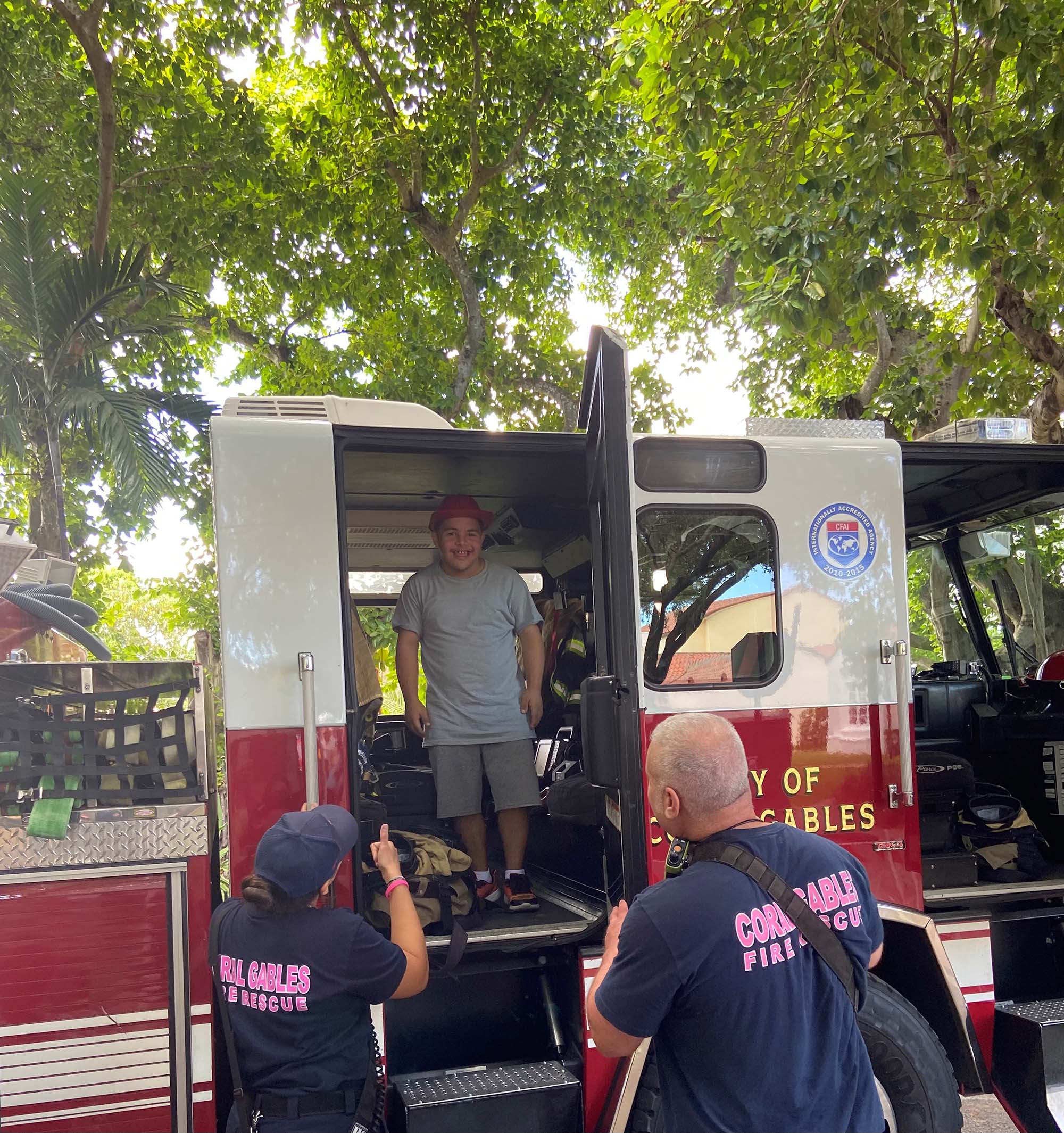 Christian Perez Centeno poses in a fire truck with members of the local fire and rescue team at Adventure Day in Coral Gables. Centeno attended the event with his uncle, APD Regional Program Supervisor Alex Perez-Viera.