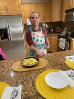 Maximillion Jaitt, with some guidance, prepares a tasty dish during a cooking class at Castanedes Group Home.